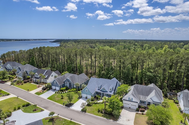 aerial view with a water view, a view of trees, and a residential view