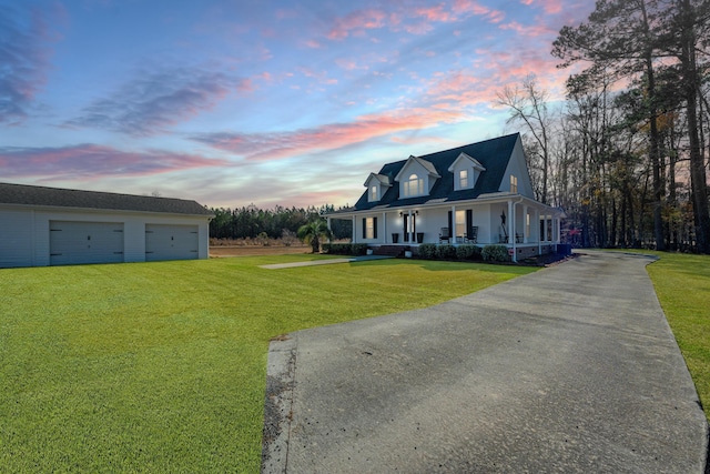 view of front of house featuring a yard, a garage, and a porch