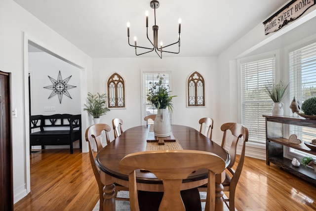 dining space with wood-type flooring and a chandelier