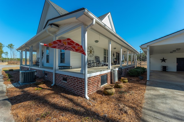 view of side of home featuring cooling unit, a carport, and covered porch