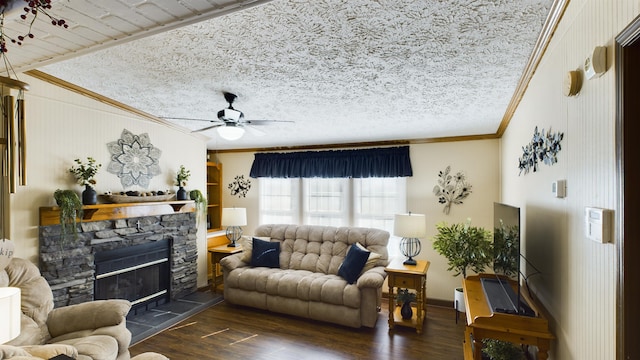 living room featuring dark wood-type flooring, a textured ceiling, ornamental molding, ceiling fan, and a fireplace