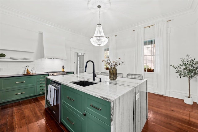 kitchen with sink, crown molding, hanging light fixtures, green cabinetry, and a center island with sink