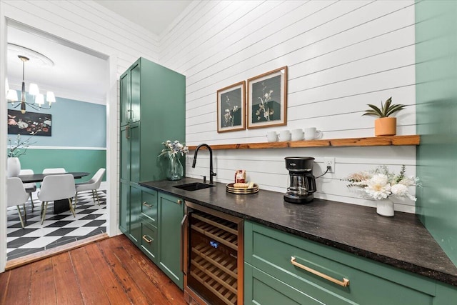 bar with green cabinetry, beverage cooler, dark hardwood / wood-style flooring, and sink