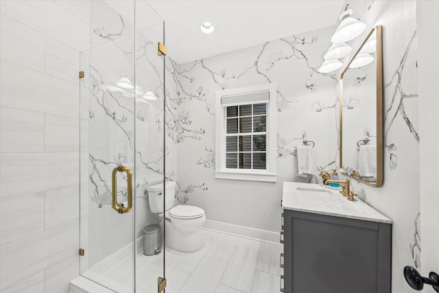 bathroom featuring vanity, a shower with shower door, and toilet