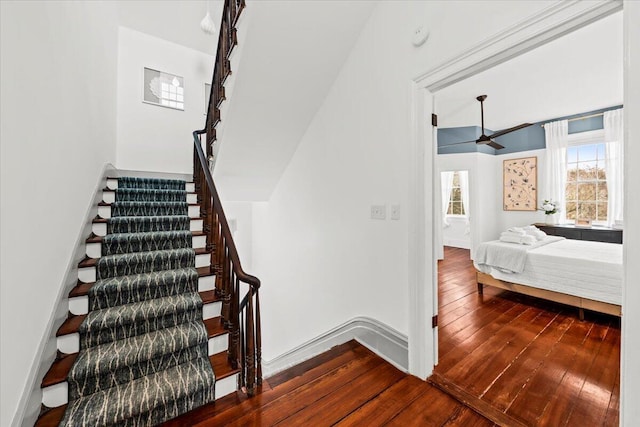 stairs featuring hardwood / wood-style flooring and ceiling fan