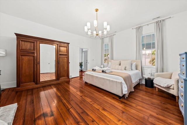 bedroom featuring dark hardwood / wood-style flooring and an inviting chandelier