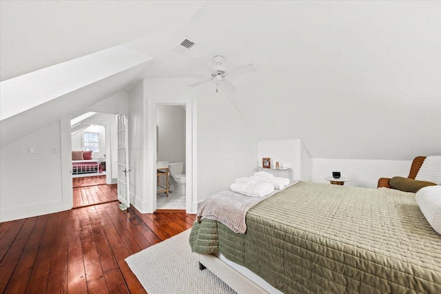 bedroom featuring ceiling fan, ensuite bathroom, dark hardwood / wood-style floors, and vaulted ceiling