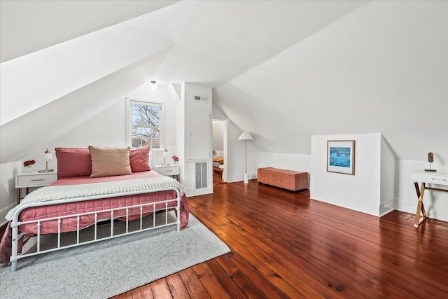 bedroom with vaulted ceiling and hardwood / wood-style floors