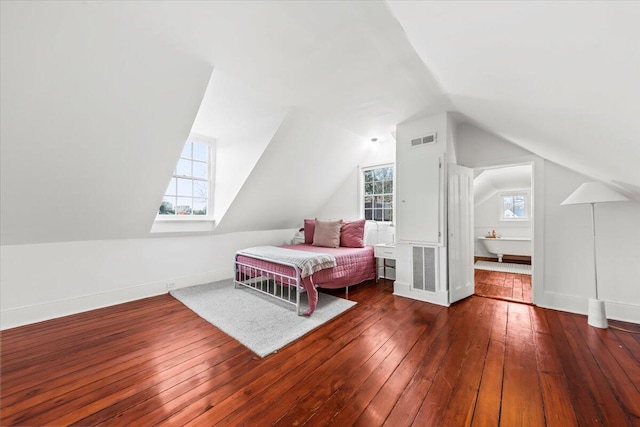 bedroom with vaulted ceiling and dark hardwood / wood-style flooring