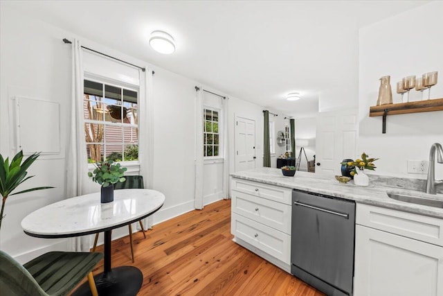 kitchen featuring sink, white cabinetry, light stone counters, light wood-type flooring, and dishwashing machine