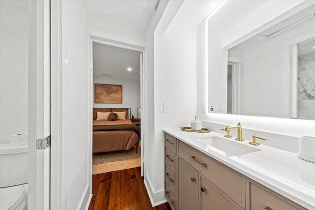 bathroom featuring wood-type flooring, toilet, and vanity