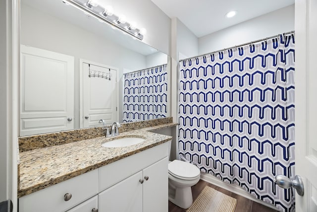 bathroom with vanity, wood-type flooring, toilet, and walk in shower