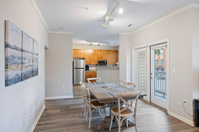 dining space with crown molding and dark hardwood / wood-style flooring