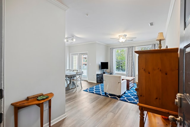 living room with ornamental molding, a healthy amount of sunlight, hardwood / wood-style floors, and ceiling fan