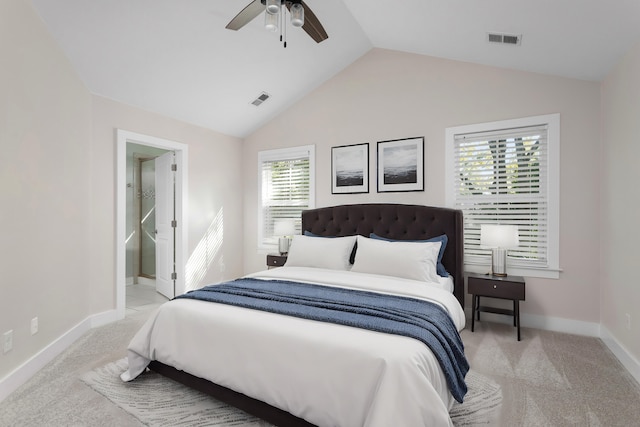 carpeted bedroom with ceiling fan, lofted ceiling, and ensuite bath