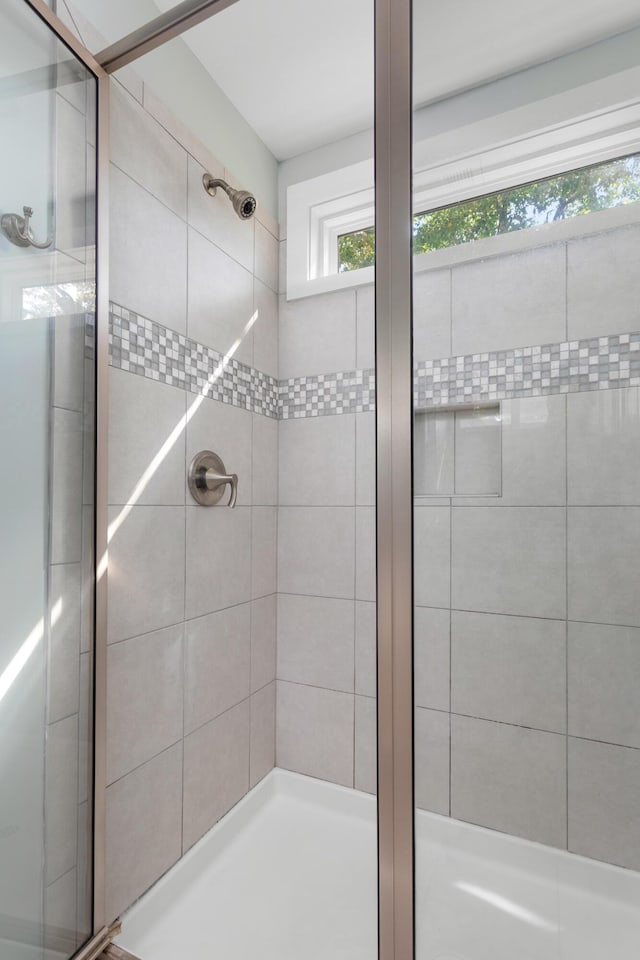 bathroom featuring a shower with door