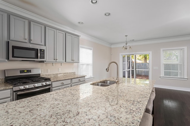 kitchen featuring crown molding, appliances with stainless steel finishes, sink, and light stone counters