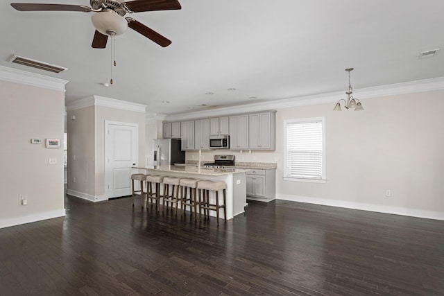 kitchen with gray cabinets, an island with sink, a kitchen breakfast bar, stainless steel appliances, and crown molding