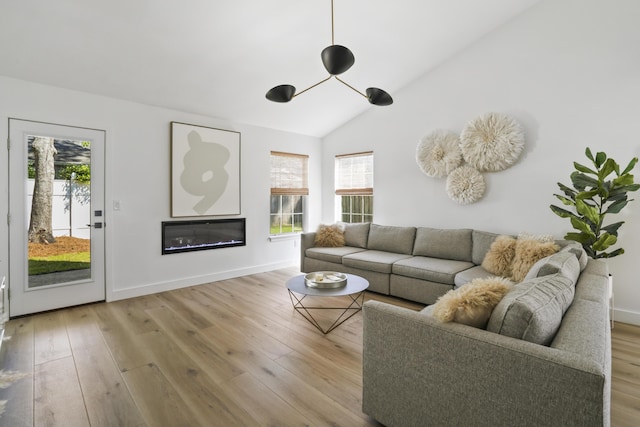 1366 W Point Dr, Mount Pleasant, SC 29466 - living room with healthy amount of natural light, wood finished floors, vaulted ceiling, a glass covered fireplace, and baseboards