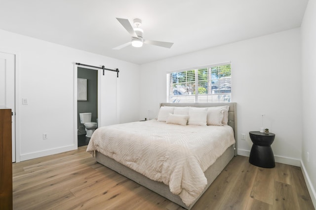 1366 W Point Dr, Mount Pleasant, SC 29466 - bedroom with a barn door, light wood-style floors, baseboards, and ensuite bath