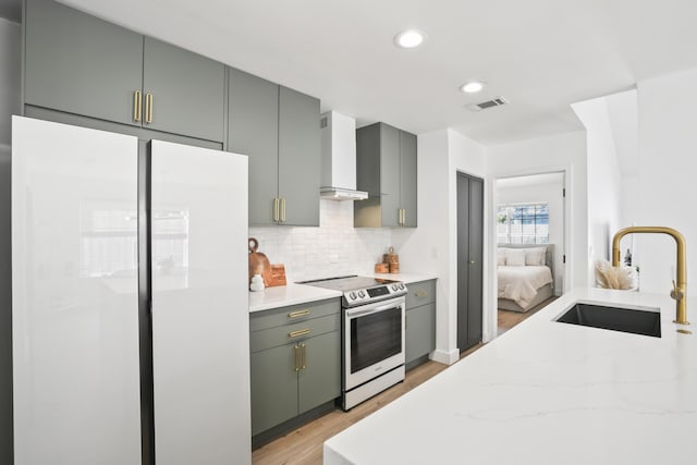 1366 W Point Dr, Mount Pleasant, SC 29466 - kitchen featuring white refrigerator, electric range, wall chimney range hood, a sink, and light wood-style flooring