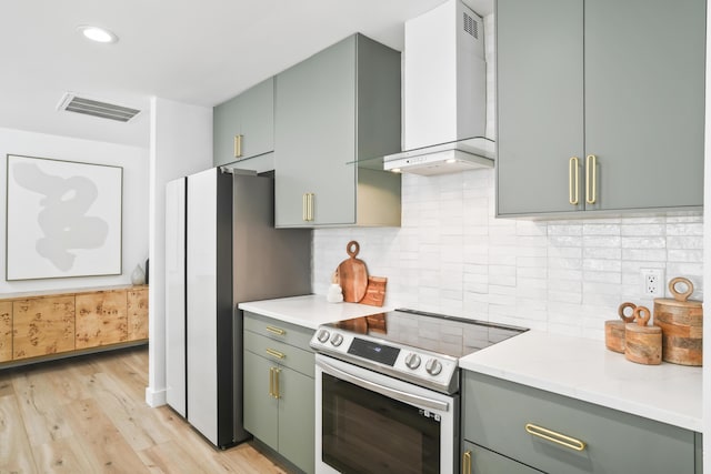1366 W Point Dr, Mount Pleasant, SC 29466 - kitchen with stainless steel electric range, wall chimney range hood, green cabinets, light wood finished floors, and recessed lighting