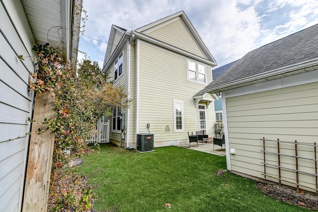 rear view of house with a lawn, a patio area, and cooling unit