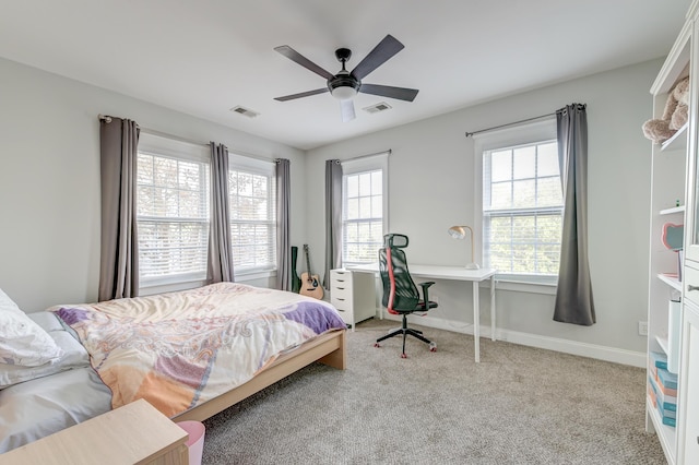 bedroom featuring ceiling fan, light colored carpet, and multiple windows