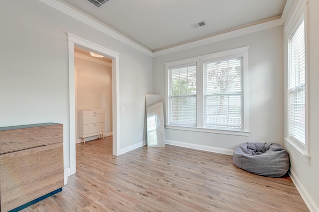 living area with light hardwood / wood-style flooring and ornamental molding