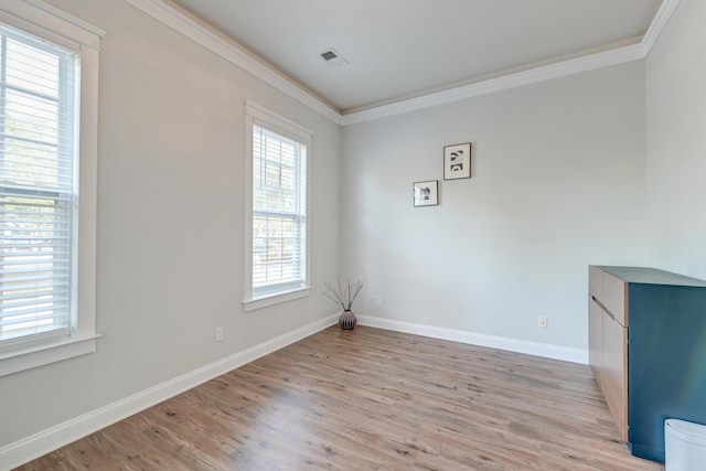 spare room with plenty of natural light, light hardwood / wood-style floors, and ornamental molding