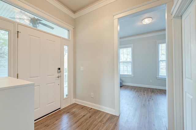 foyer with light hardwood / wood-style floors and crown molding