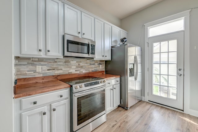 kitchen featuring white cabinets, light hardwood / wood-style floors, stainless steel appliances, and wooden counters