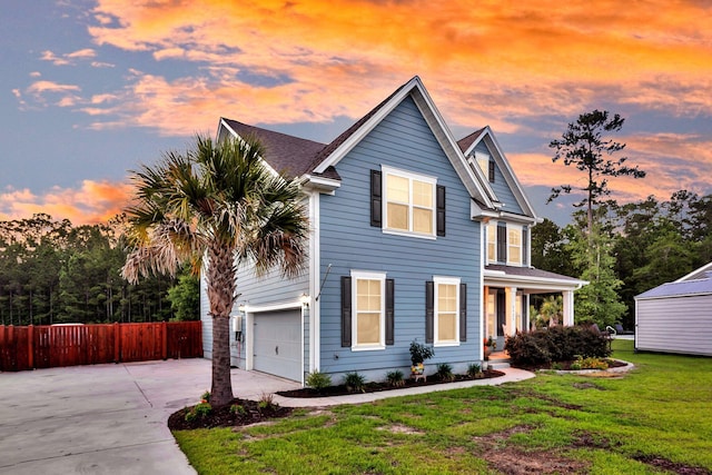 traditional-style home with concrete driveway, a porch, and a garage