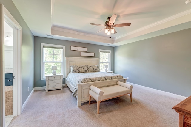 bedroom featuring a tray ceiling, light colored carpet, crown molding, multiple windows, and baseboards