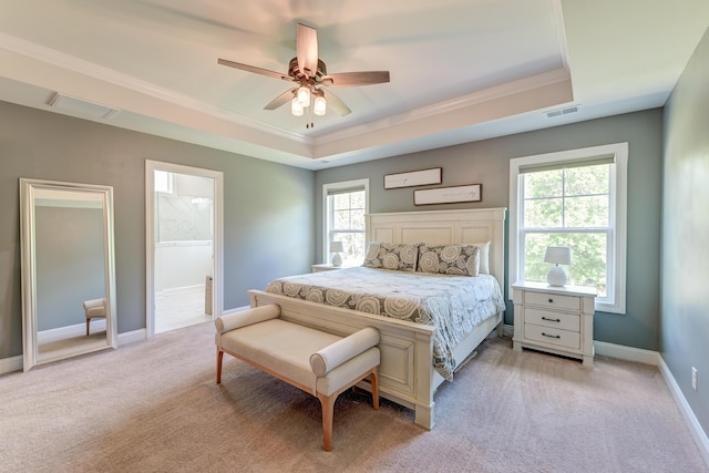 bedroom with a raised ceiling, multiple windows, light carpet, and crown molding