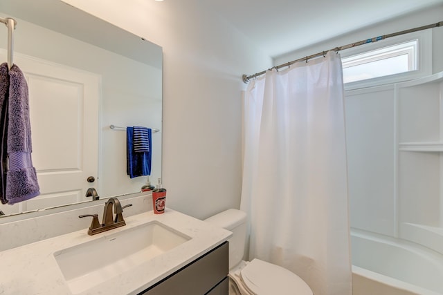 bathroom featuring toilet, vanity, and shower / bath combo