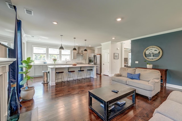 living area with crown molding, baseboards, recessed lighting, dark wood-style flooring, and a high end fireplace