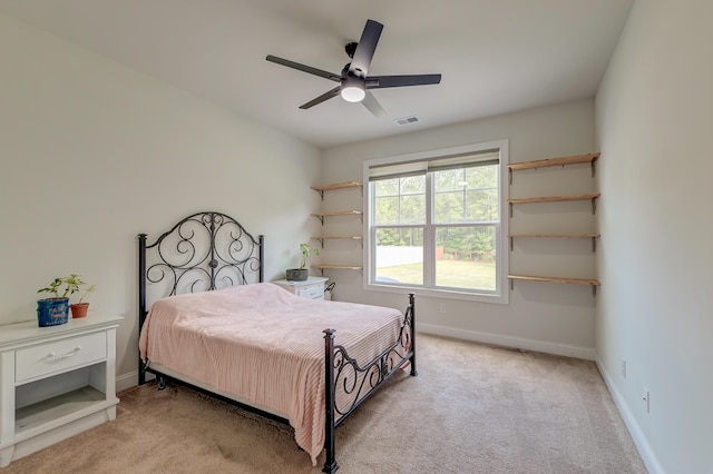 bedroom featuring light colored carpet, baseboards, and ceiling fan