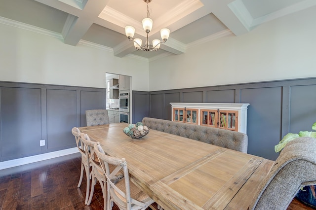 dining space with a decorative wall, coffered ceiling, beam ceiling, a chandelier, and dark wood-style flooring
