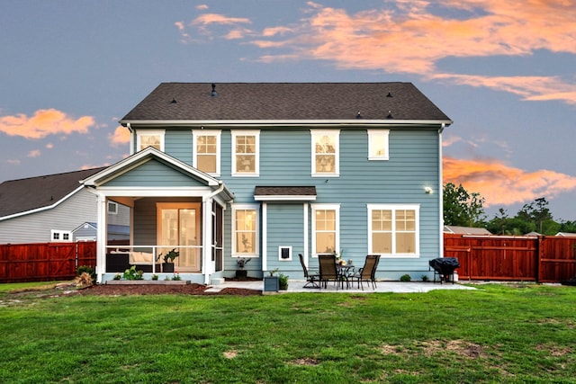 back of house at dusk featuring a patio area and a sunroom