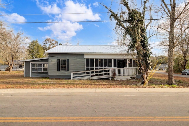 view of front facade featuring a front yard and a sunroom