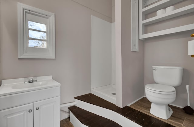 bathroom with walk in shower, vanity, and toilet