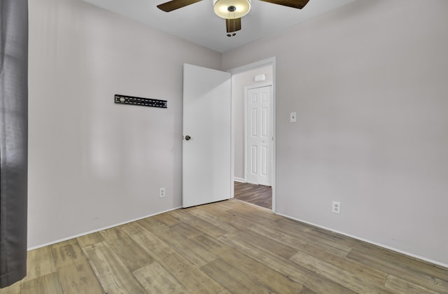 empty room with ceiling fan and light hardwood / wood-style flooring