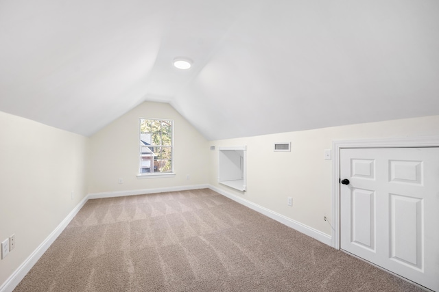 bonus room with light colored carpet and lofted ceiling