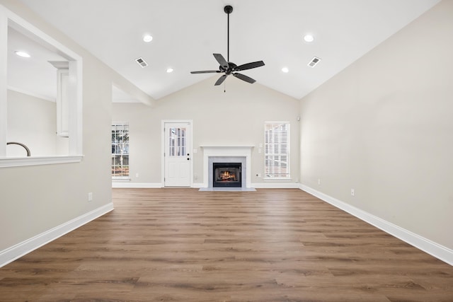 unfurnished living room featuring ceiling fan, dark hardwood / wood-style flooring, a fireplace, and high vaulted ceiling