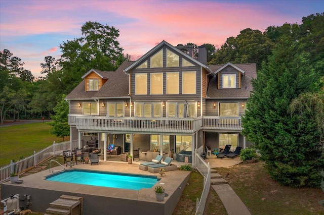 back of property at dusk with an outdoor hangout area, a patio area, a fenced backyard, and a chimney