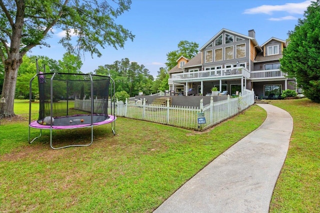 rear view of house featuring a trampoline and a chimney