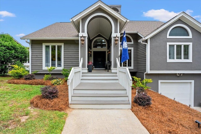 view of front of property with a garage and roof with shingles