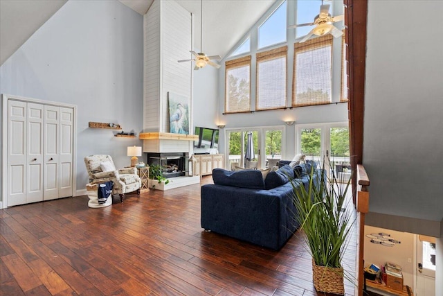 living room with high vaulted ceiling, ceiling fan, a large fireplace, and hardwood / wood-style flooring