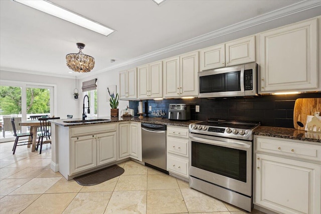 kitchen with stainless steel appliances, a sink, a peninsula, crown molding, and decorative backsplash